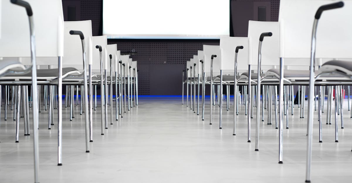 Empty modern conference room with white chairs in rows, ready for a presentation.