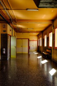 Bright corridor in a Zaragoza school with sunlight streaming through windows, creating a warm ambiance.