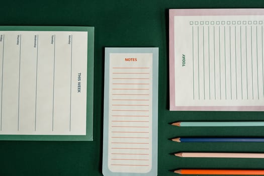 Top view of various notebooks and pencils for effective planning.